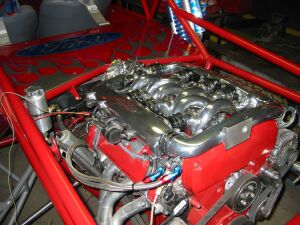 1993 Ford Taurus - This custom V8 engine features polished intake runners and bright red engine block paint, suggesting a high-performance build.