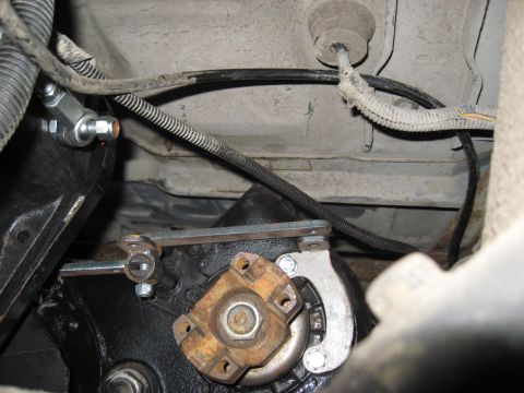 1991 Ford Bronco - Underside view of a vehicle's drivetrain components, including a U-joint and linkage mechanism.