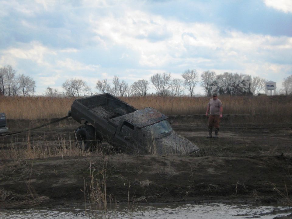 Mud-covered pickup truck stuck in a muddy field