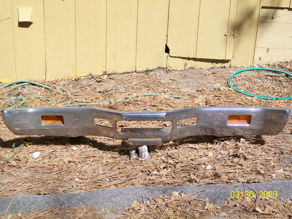 Chrome front bumper with two amber marker lights and a central grille opening