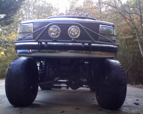 1996 Ford Bronco - A heavily modified 1992 Ford Bronco is shown from the front, equipped with oversized tires and a custom brush guard.