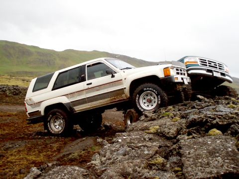 1996 Ford Bronco - Two SUVs navigate a challenging rocky landscape under an overcast sky.