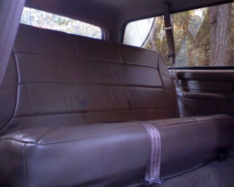1996 Ford Bronco - Interior view of a rear bench seat with a seatbelt, seen through the windows of a vehicle.