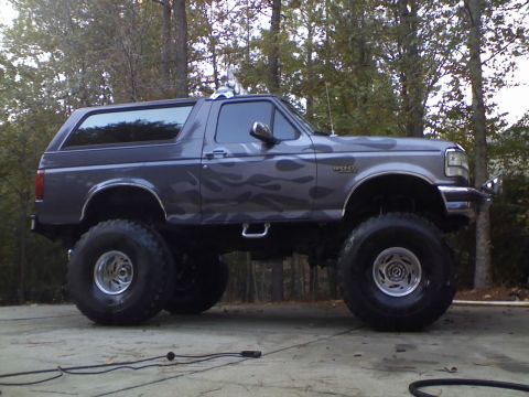1996 Ford Bronco - This lifted 1996 Ford Bronco features a custom flame graphic paint job and oversized tires.