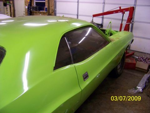 1974 Dodge Challenger - A lime green 1974 Dodge Challenger is shown in a garage, possibly undergoing restoration.