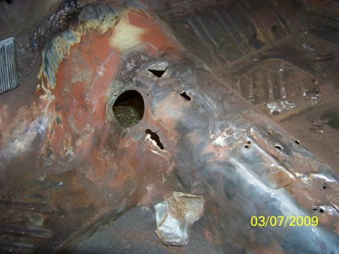 1974 Dodge Challenger - This photo shows a heavily rusted car floor pan with several holes and visible damage.