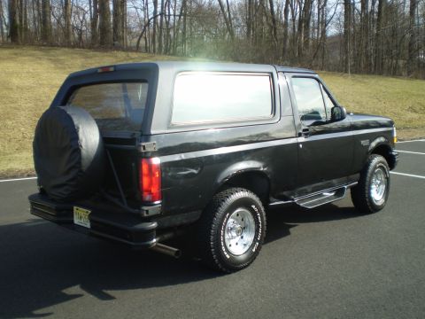 1996 Ford Bronco - This 1996 Ford Bronco is viewed from the rear three-quarter angle, showing its black exterior and spare tire.