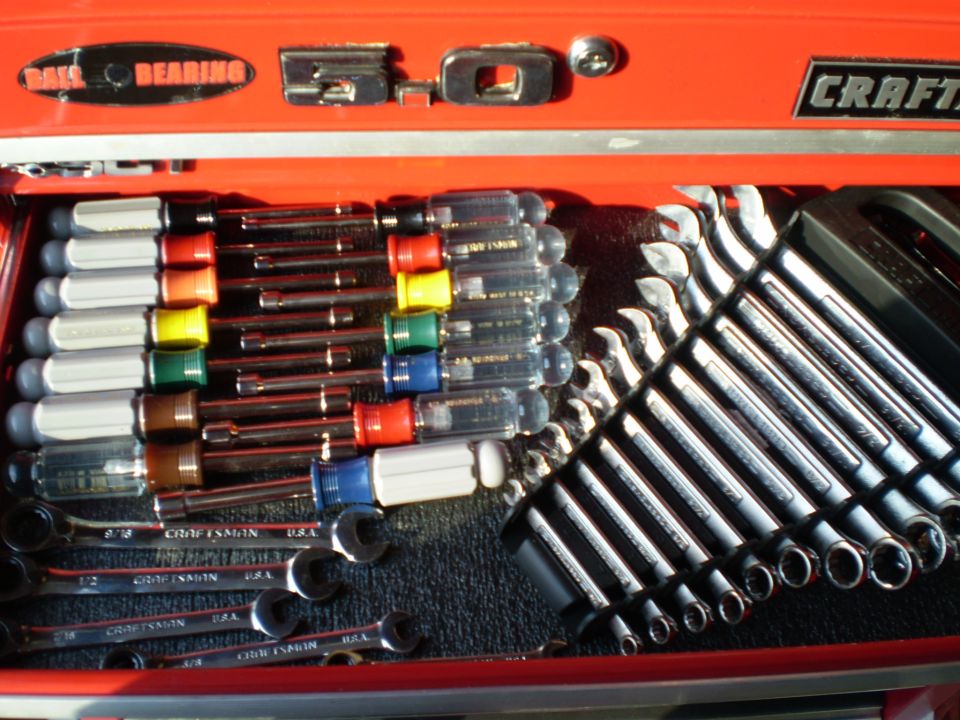 Open red Craftsman tool chest drawer with screwdrivers and combination wrenches