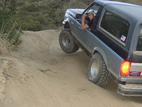 1989 Ford Bronco - Driver gives a thumbs up while piloting a 1989 Ford Bronco on a steep dirt incline.
