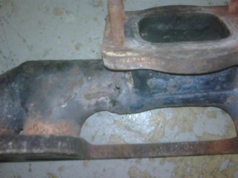 1986 Toyota Hilux - This is a close-up view of a rusty exhaust manifold, likely a vehicle part.