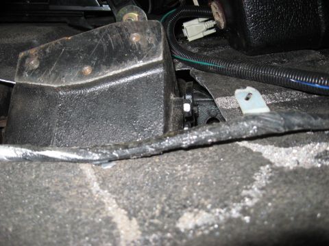 1991 Ford Bronco - Close-up view of an interior mechanical part, possibly related to the drivetrain or undercarriage, with visible wiring and mounting hardwar…