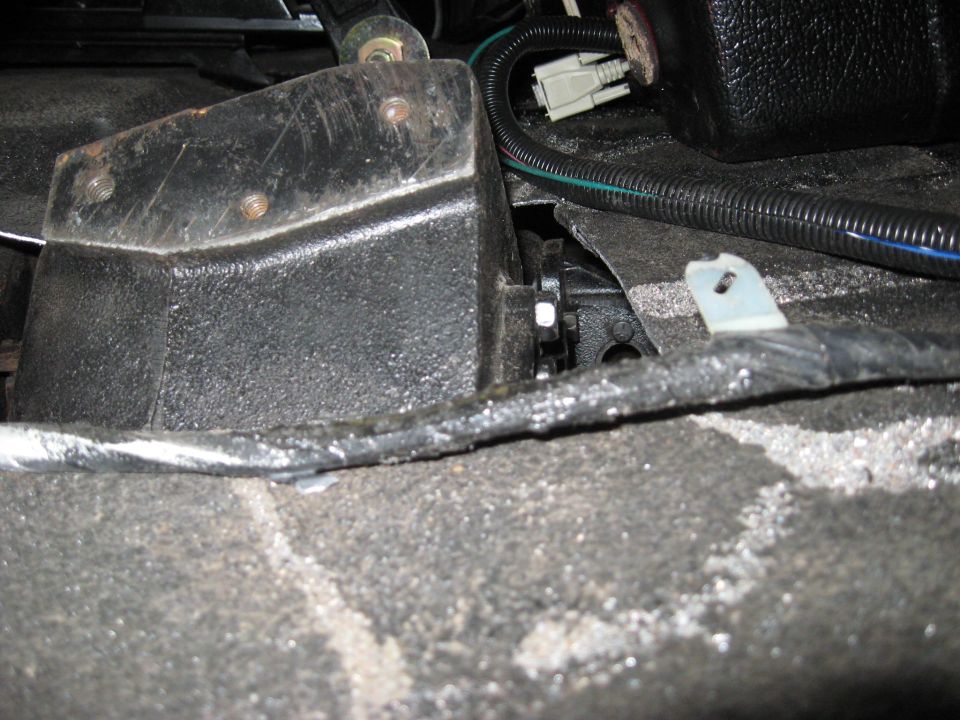 Interior view of a black metal mechanical component with wiring and a white clip