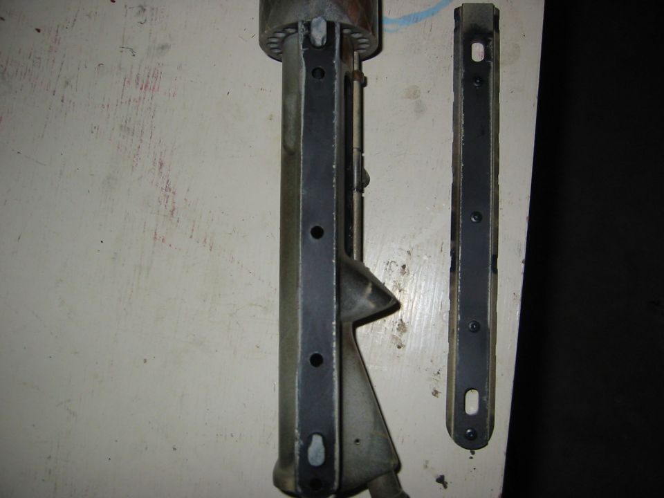 Two metal brackets with screw holes, one longer than the other