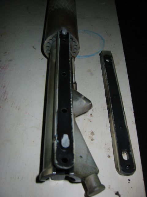 1996 Ford Bronco - A disassembled metal component, possibly from a vehicle's suspension or frame, is shown on a workbench.