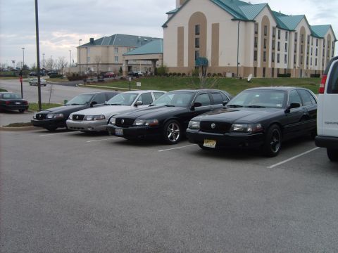 1993 Ford Crown Victoria - Multiple sedans are parked in a lot, with one in the foreground appearing to be a 2003 Ford Crown Victoria.