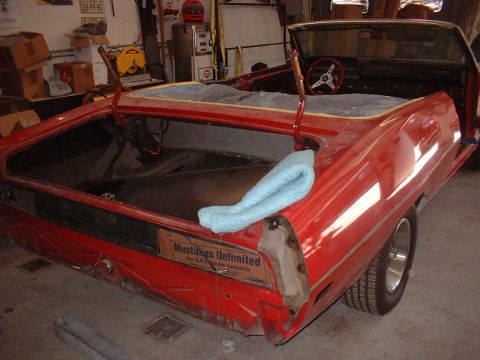 1970 Ford Torino - A red 1970 Ford Torino convertible is shown in a garage with its trunk open, undergoing restoration.