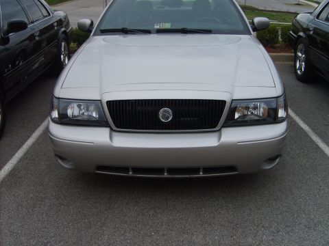 1993 Ford Crown Victoria - The front of a silver sedan is visible, parked in a lot next to another vehicle.