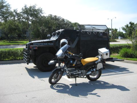 2004 BMW R1150GS ABS Adventure - A BMW motorcycle is parked next to a large, black armored vehicle labeled 'Huntington Park Police'.