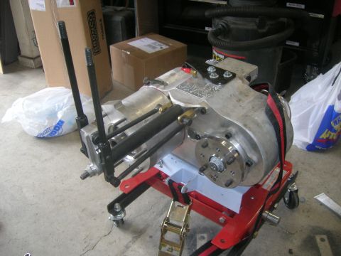 1996 Ford Bronco - A transfer case is mounted on a red stand, ready for installation or service.