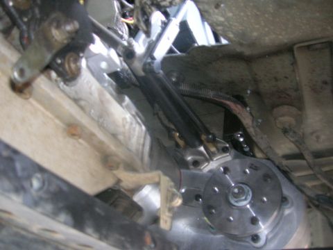 1996 Ford Bronco - Close-up of the transmission and linkage system from underneath a vehicle.