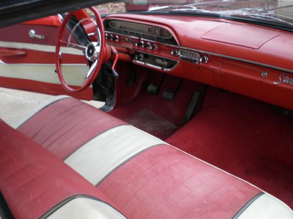 Vintage car interior with red and white bench seat and red dashboard