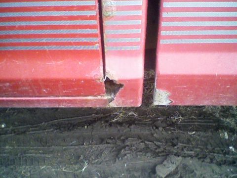 1992 Ford Ranger - Close-up of rust damage on a red truck's door seam, showing horizontal silver stripes.
