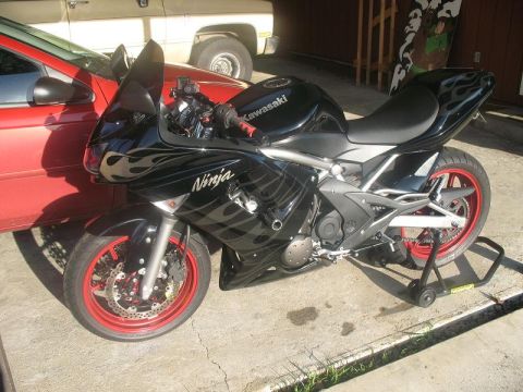 2008 Kawasaki Ninja R - A black Kawasaki motorcycle with flame decals and red rims is parked on a stand.