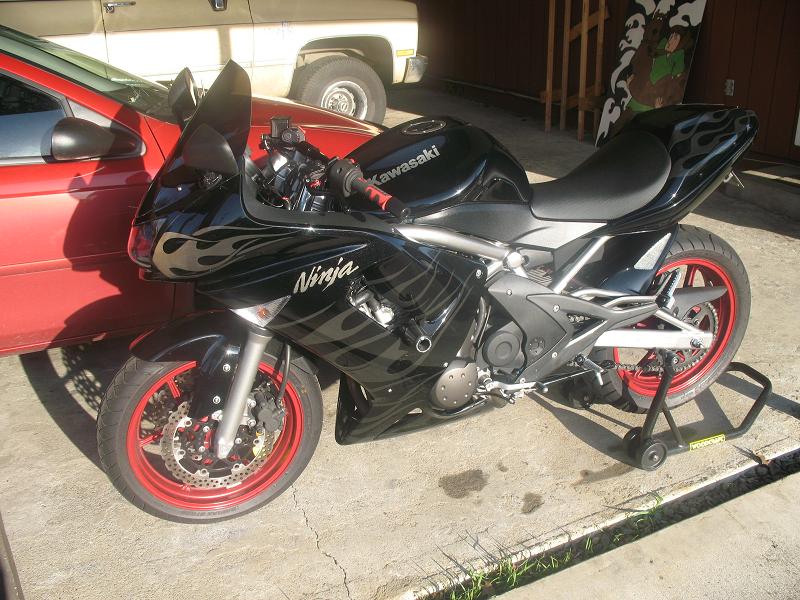 Black Kawasaki motorcycle with flame decals and red rims