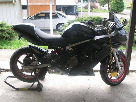 2008 Kawasaki Ninja R - A black Kawasaki Ninja R motorcycle is parked on a stand, showing its side profile with red accents on the wheels.