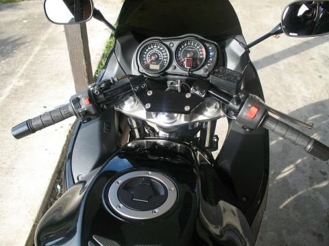 2008 Kawasaki Ninja R - The dashboard and controls of a black motorcycle are shown, including the speedometer and tachometer.