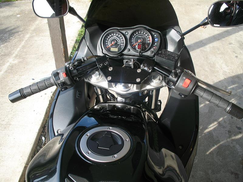 Close-up of motorcycle handlebars, gauges, and fuel tank