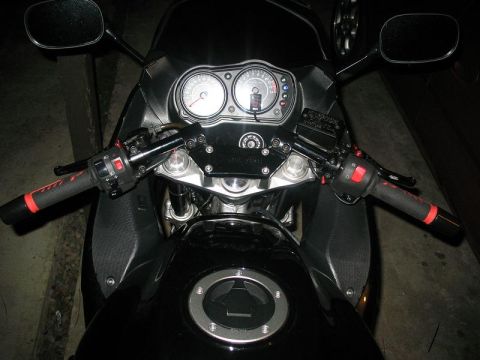 2008 Kawasaki Ninja R - Close-up view of the handlebars and instrument cluster of a black motorcycle.