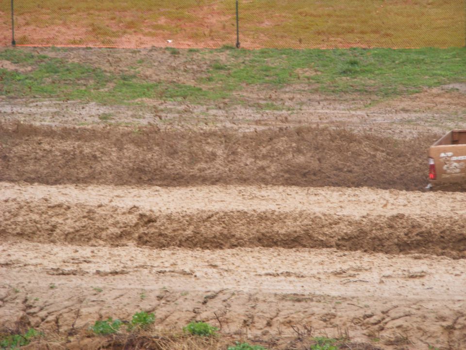 Tan pickup truck driving through mud