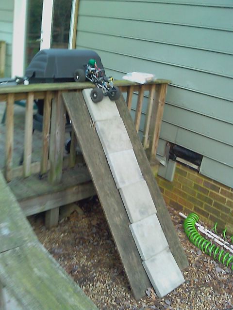 1996 Ford Bronco - RC car on a homemade ramp made of wood and pavers, with a grill in the background.