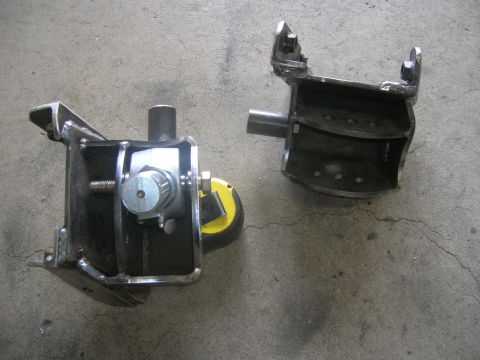 1996 Ford Bronco - Two custom fabricated steel suspension components are shown on a concrete surface. The component on the left features a threaded rod and a…