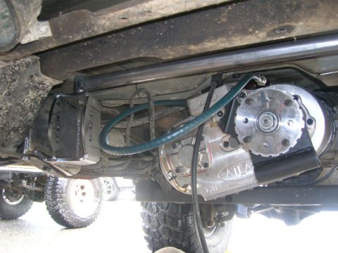 1996 Ford Bronco - The underside of a 1996 Ford Bronco shows a transfer case modification with a green hose connected to it. The vehicle has large off-road ti…