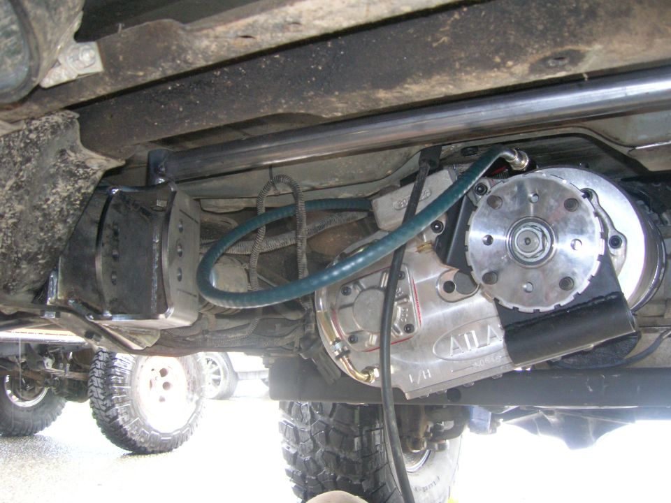 Underside of a 1996 Ford Bronco showing a transfer case modification and off-road tires.