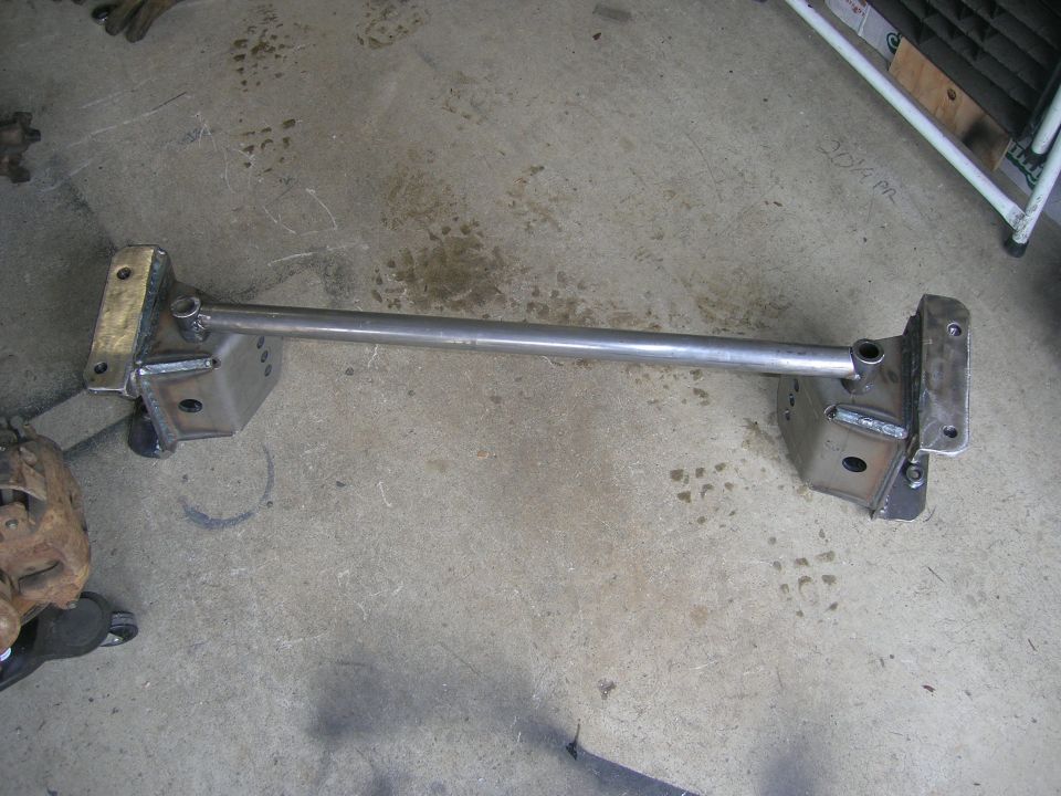 Custom fabricated steel crossmember with mounting brackets on concrete floor