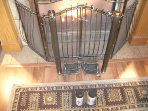 1996 Ford Bronco - A fireplace screen with two metal stands in front of it. Two cans of spray paint are on a rug in the foreground.