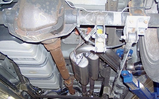 Photo of a vehicle undercarriage with differential, driveshaft and exhaust muffler