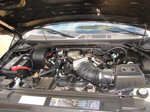 2007 Ford Mustang - Engine-bay photograph of an SUV showing the intake and emissions decal, not a document.