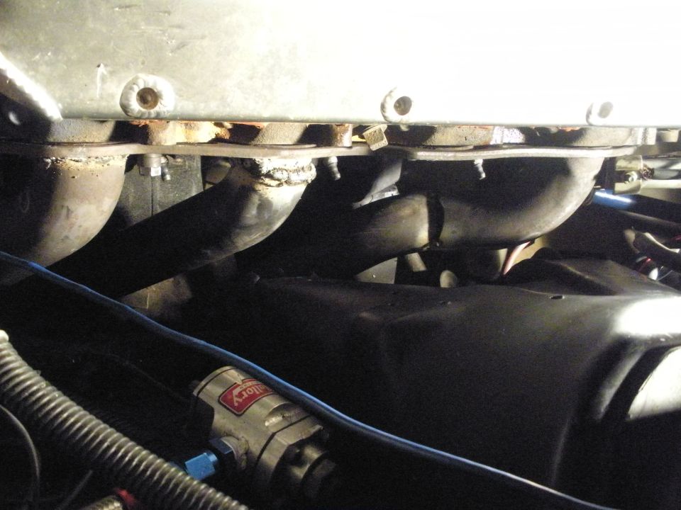 Engine bay detail showing exhaust pipes and a Mallory fuel filter.