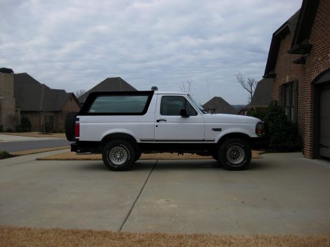 1996 Ford Bronco - Side view of a white 1996 Ford Bronco parked in a driveway.