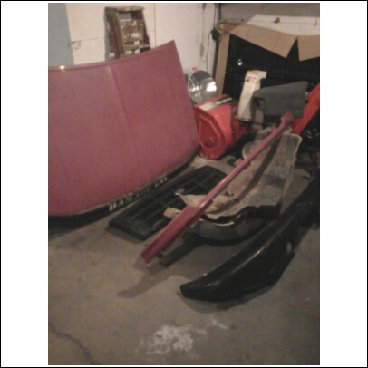 1994 Ford F-250 - Various car parts are stored in a garage, including a red hood and black fender sections.
