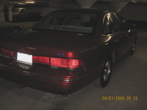1997 Ford Crown Victoria - Rear view of a red Ford Crown Victoria parked in a garage with a timestamp overlay.