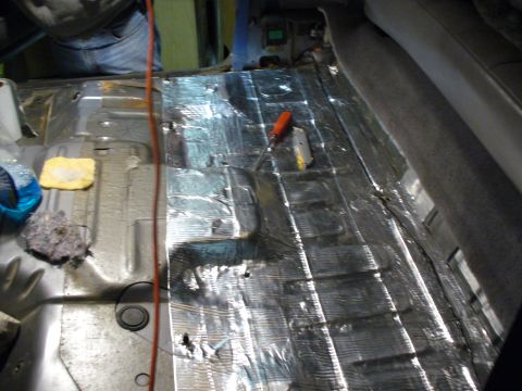 1994 Ford Bronco - Installing soundproofing material on the floor of a vehicle's interior.