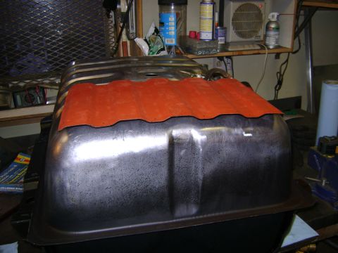 1989 Ford Bronco - Fuel tank with an orange gasket is visible on a workbench, likely for repair or replacement.