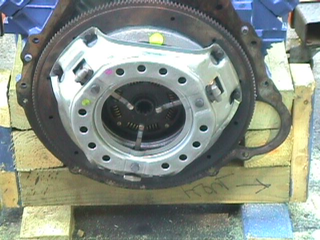 close-up of engine clutch and flywheel assembly on wooden blocks