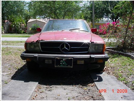 1994 Ford Bronco - Front view of a red Mercedes-Benz SL parked on a driveway, showing signs of wear and tear on the hood and bumper.