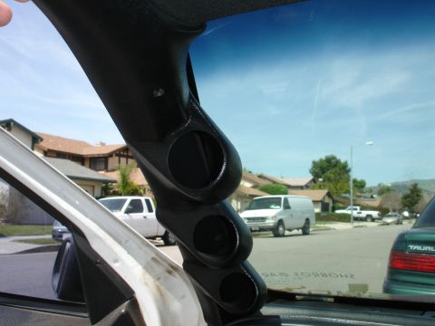 1993 Ford Taurus - A custom gauge pod is installed on the A-pillar, obscuring the view of parked vehicles and houses outside.